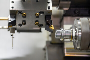 The  dual spindle type CNC lathe machine forming cutting the metal shaft parts.