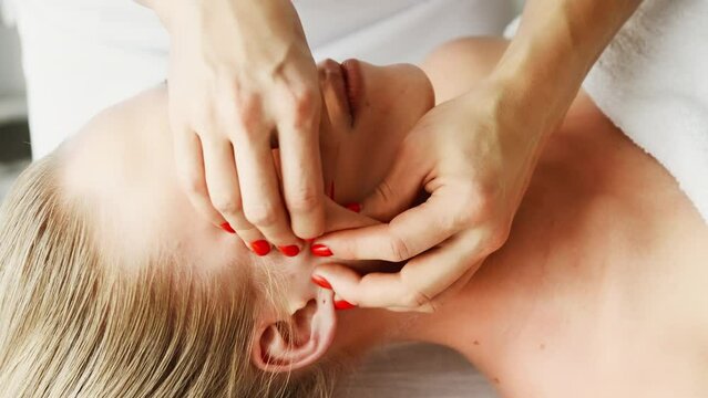 Beautician cosmetologist makes lifting massage nasolabial folds, pinch and roll technique, professional cosmetic procedure in a beauty clinic salon for client. Skin care and cosmetology spa concept.	