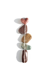 Aesthetic minimal sea pebble with white line and heart stone on white background. Natural color stone on the same level at sunlight. Balance, harmony, romance concept, vertical row rocks.