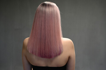 Back view of model with dyed hair on gray background