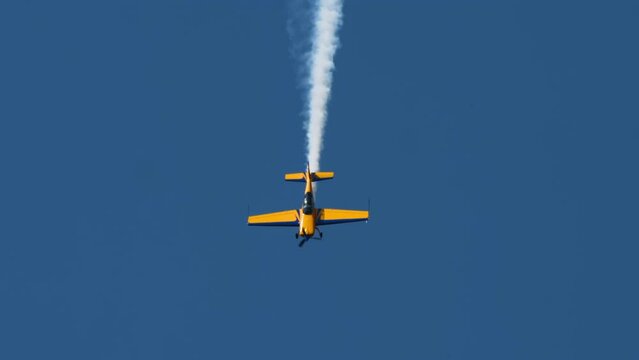 A light-engine plane flies vertically down at an air show. Extreme demonstrations, sports plane flights