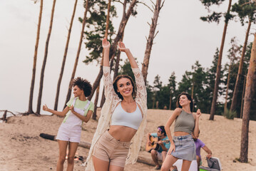 Photo of positive cheerful people enjoy free time hanging out dancing beach outside