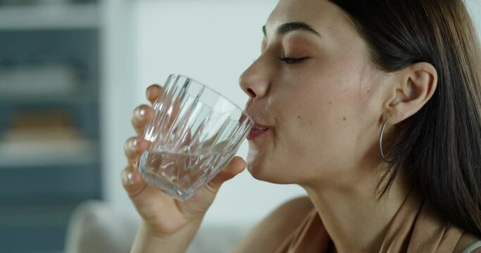 Young woman drinks a glass of water