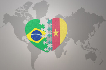 puzzle heart with the national flag of brazil and cameroon on a world map background.Concept.