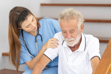 Man being cared for by a private Asian nurse at home suffering from Alzheimer's disease to closely care for elderly patients