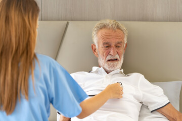 Man being cared for by a private Asian nurse at home suffering from Alzheimer's disease to closely care for elderly patients