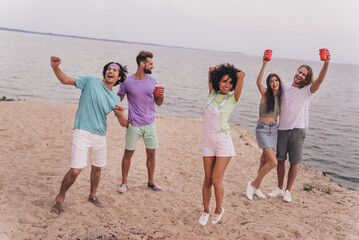 Full body photo of overjoyed funny people enjoy alcohol drinks dancing free time outside