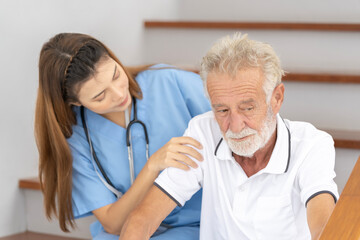 Man being cared for by a private Asian nurse at home suffering from Alzheimer's disease to closely care for elderly patients