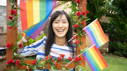 Diversity female Asian cheerful young Thai women with rainbow flag gay pride while leisure in the park. Concept of homophobia and diversity lesbians.Supporters of the LGBT community.African Asian