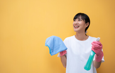 Smiling Asian woman holding bottle chemistry and cloth for cleaning house show thumb up. Isolated...