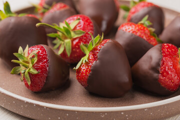 Gourmet chocolate covered strawberries on ceramic plate. Dessert background.  Selective focus.