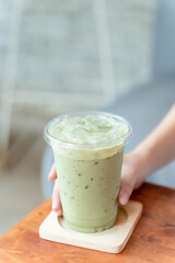 hand holding a cup of iced green tea
