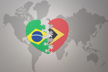 puzzle heart with the national flag of brazil and east timor on a world map background.Concept.