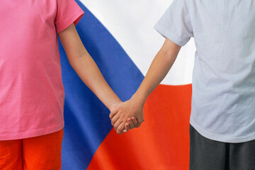 Boy and girl joined hands on background flag of Czech Republic