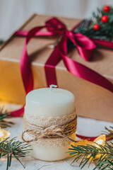 Hand decorated Christmas candle with gift box with a bow tie on background 