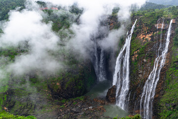 A beautiful view of waterfalls with clouds near it.