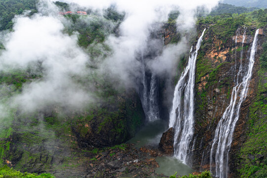 A beautiful view of waterfalls with clouds near it.