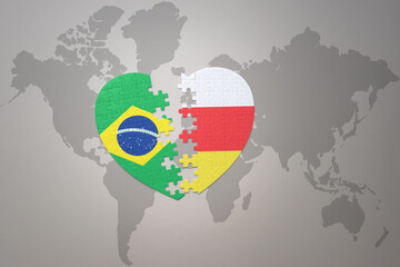 puzzle heart with the national flag of brazil and south ossetia on a world map background.Concept.