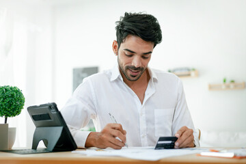 Fototapeta premium Handsome businessman in a white dress Happy working at home. Working at home. Handsome young man in work clothes. Happy working.