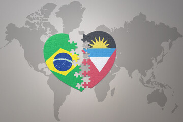 puzzle heart with the national flag of brazil and antigua and barbuda on a world map background.Concept.