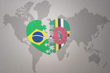 puzzle heart with the national flag of brazil and dominica on a world map background.Concept.