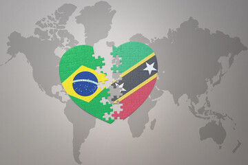 puzzle heart with the national flag of brazil and saint kitts and nevis on a world map background.Concept.