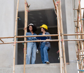 The engineer manager and female foreman are standing on the construction site to check the various...