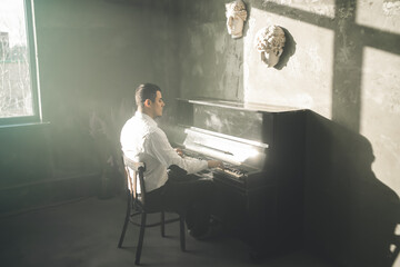 Composer man play on the old piano. Keyboards. Performance on the concert. Musician plays....