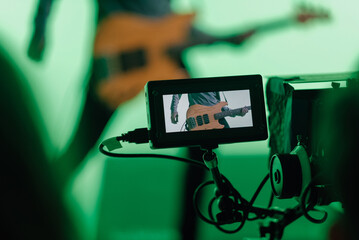 Close up of a screen connected to the camera recording music video clip of bass guitarist playing