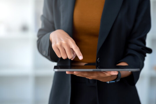 Closeup image of female using digital tablet to send text , work or play social media in office.