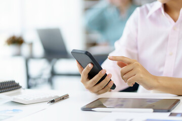 Closeup image of female using smartphone to send text , work or play social media.
