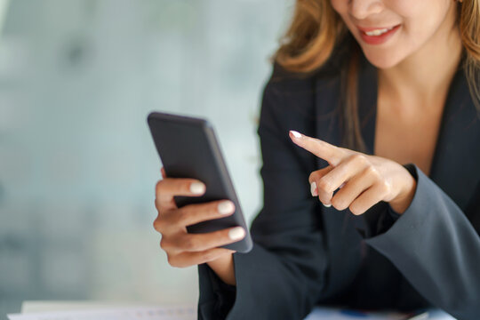 Closeup image of female using smartphone to send text , work or play social media.