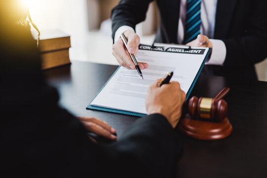 male lawyer pointed to a legal document explaining the terms of a consultation with a business woman. before signing a contract with a law firm