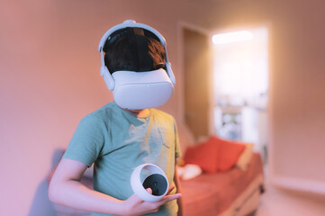 Cinematic night portrait amazed young kid wearing virtual reality goggles. Active Boy playing video games looking in VR headset. Child  experiencing 3D gadget in living room at night