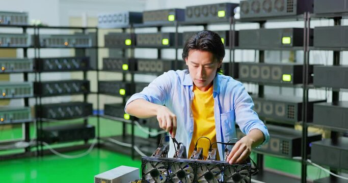 asian man assembling mining machine