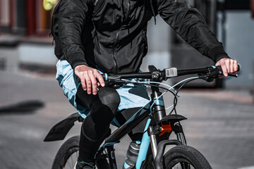 Fototapeta na wymiar fashionable man in sportswear rides a bicycle along the city street.