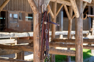 in front of a stable hangs on a post on a horseshoe hung leather thong for a horse
