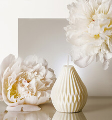 Elegant wax candle and peonies.