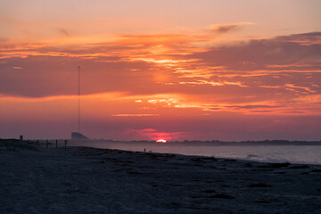 Naklejka na ściany i meble The Sun rises over the Cape May National Wildlife refuge as seen from the beach in cape may New Jersey
