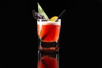 Red cocktail with alcohol. On a black background.