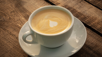 Cappuccino in a white cup on a wooden table