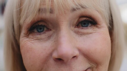 Close-up elderly female face blue eyes mature smiling woman satisfied with ophthalmic procedure patient ophthalmological clinic vision correction aging wrinkled skin cosmetology service for facelift