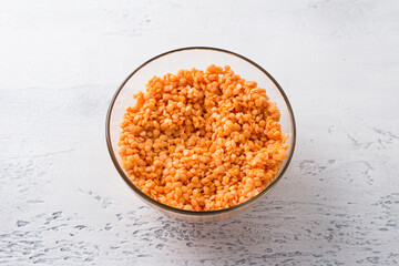 Raw soaked lentils in white bowl on light gray background, top view. Healthy Food Concept