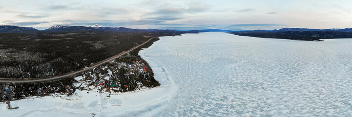 Aerial view from a large frozen lake on the Yukon River during winter time. 