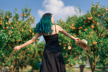 happy asian woman greeny hair in organic orange plantation garden