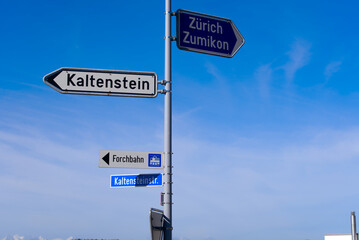 Fototapeta premium Direction signs with street lights and scenic rural landscape at village Forch, Canton Zürich, on a sunny summer day. Photo taken June 8th, 2022, Forch, Switzerland.