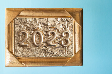 Golden textures, frame, paper and numbers 2023 isolated on blue background. New year layout. 