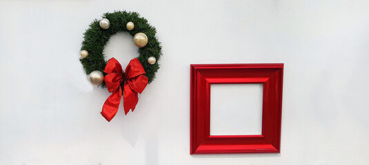 Christmas, happy new year wreath decoration with red ribbon, white ball and red picture frame for add wording isolated on white wall background. Object for decorated party, festival with copy space. 