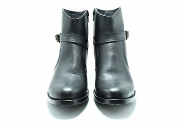 Botines de cuero color negro. Calzado de tacon bajo sobre fondo blanco, vista frontal.