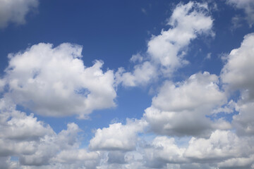 Isolated blue summer sky cloudscape photo with white fluffy fair weather cumulus clouds
